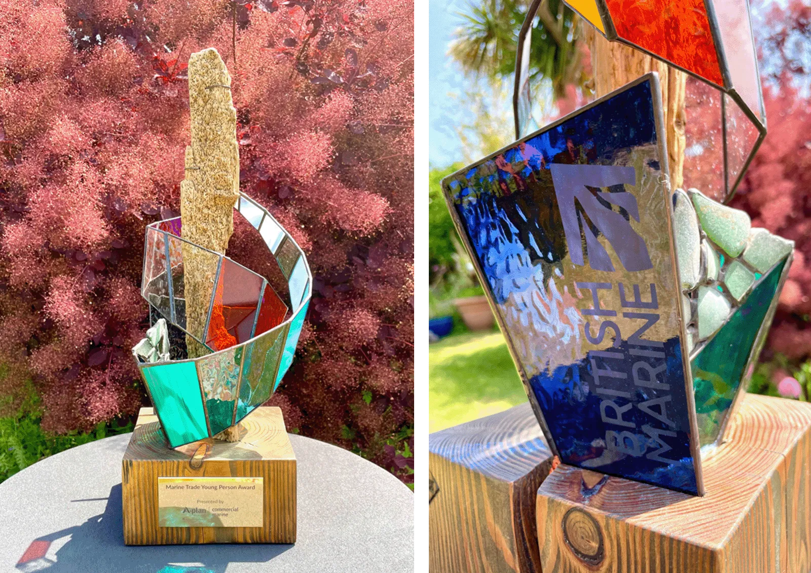 A colorful, abstract sculpture with a wooden base, depicting a ship's sail, awarded by British Marine.