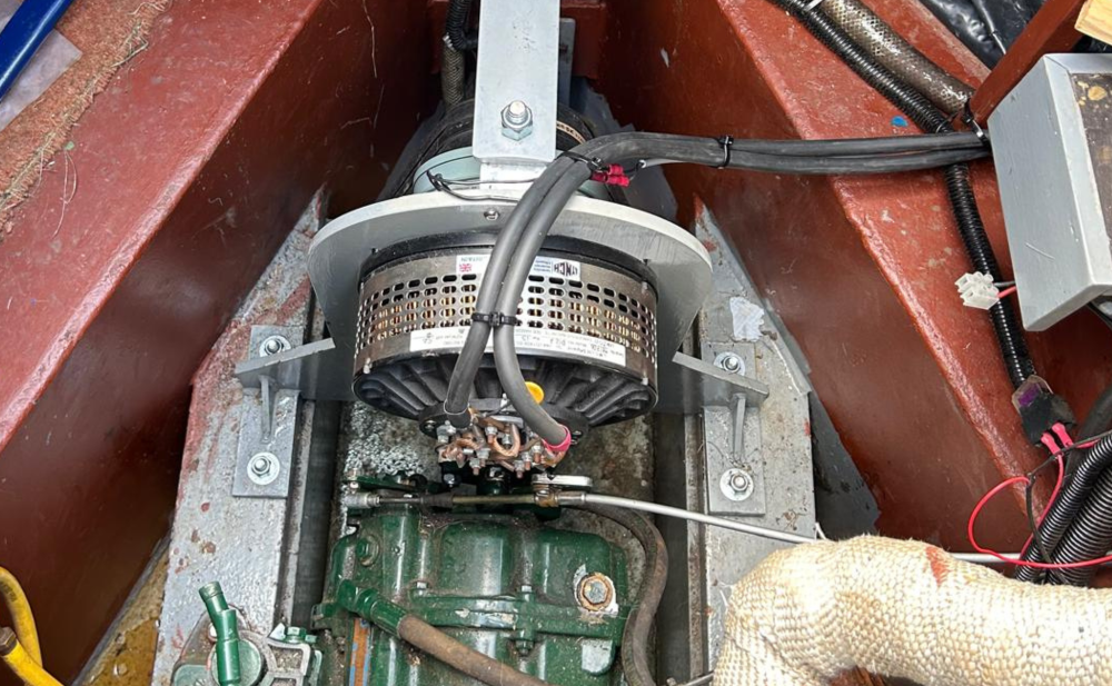 Close-up of a boat's internal machinery showcasing bolted components, electrical wiring, and a centralized motor assembly.